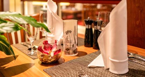 a wooden table with a table cloth and a table with glasses at PLAZA INN Goslar in Goslar
