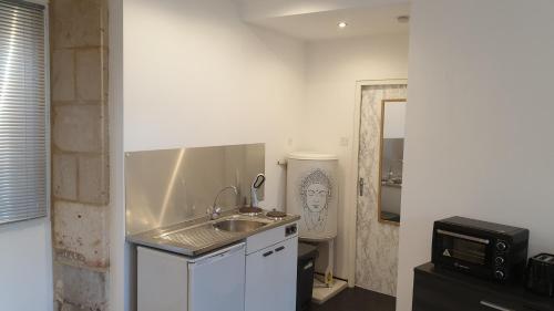 a small kitchen with a sink and a microwave at Studio 2 - 3 minutes du Futuroscope in Chasseneuil-du-Poitou