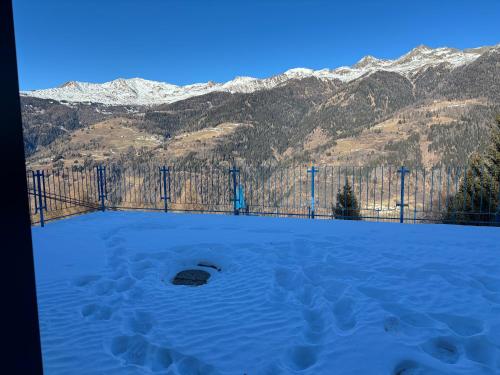 a gate in the snow with mountains in the background at La Tana del Gufetto in Marilleva