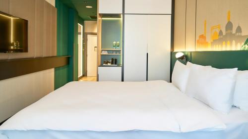 a bedroom with a large white bed in a room at Holiday Inn Tashkent City by IHG in Tashkent