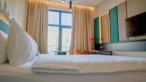 a hotel room with a bed and a large window at Holiday Inn Tashkent City by IHG in Tashkent
