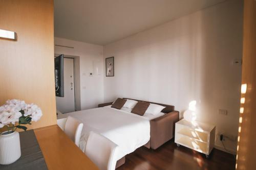 een witte slaapkamer met een bed en een tafel bij Giax Panoramic View Parking in Milaan