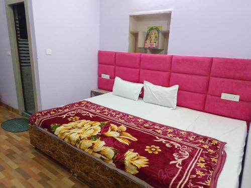 a large bed with a pink headboard in a room at TEJAS HOMESTAY JUST 2 MINUTES from GOLDEN TEMPLE in Amritsar