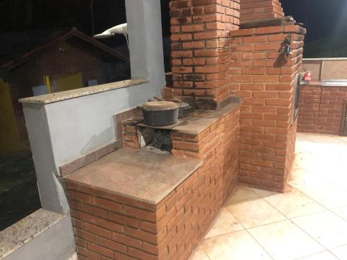 a brick oven with two pots on a brick wall at Chácara Puro Malt in Mairiporã