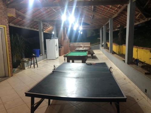 a ping pong table in the middle of a room at Chácara Puro Malt in Mairiporã