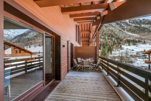 a balcony with a table and chairs on it at l'Ours Bleu B33 ski -in ski -out - Happy Rentals in Vallorcine