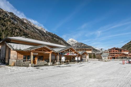 a ski lodge with mountains in the background at l'Ours Bleu B33 ski -in ski -out - Happy Rentals in Vallorcine