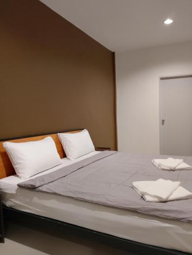 ein großes Bett mit weißen Kissen in der Unterkunft Sheep House บ้านนับแกะ in Ban Don Rak