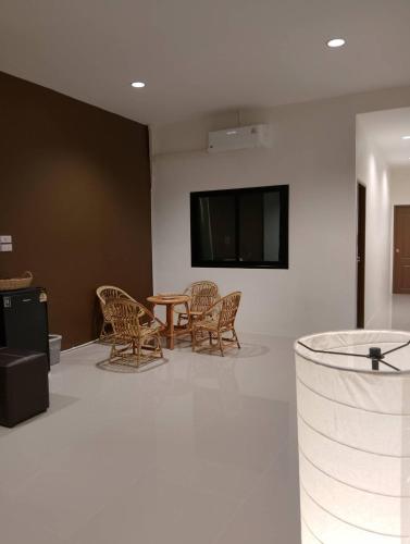 a room with a table and chairs and a tv at Sheep House บ้านนับแกะ in Ban Don Rak
