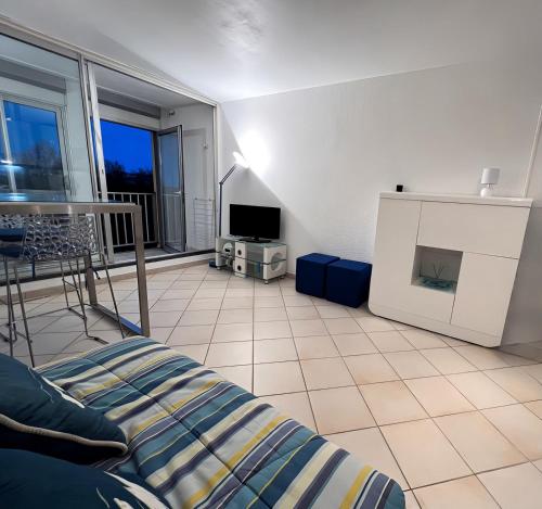 un salon avec un lit et une télévision dans l'établissement Studio vue mer, au Cap d'Agde