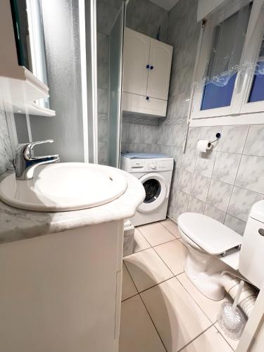 La salle de bains blanche est pourvue d'un lavabo et d'un lave-linge. dans l'établissement Studio vue mer, au Cap d'Agde
