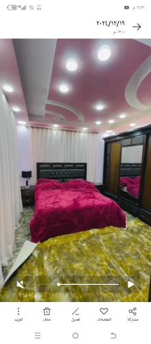 a bedroom with a bed with a pink comforter at اربد طريق البترول دبج مول فيلا مزرعة مفروشة للايجار يومي أسبوعي شهري in Juḩfīyah