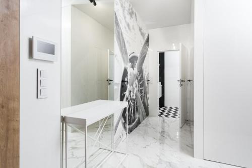 une chambre avec une table et un tableau sur le mur dans l'établissement Golden Apartments Warsaw - Luxury 2-Bedroom, Mennica Residence&166, à Varsovie