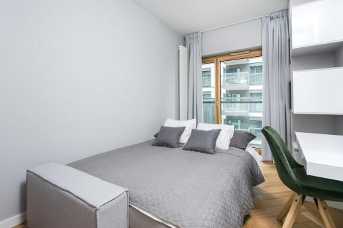 une chambre avec un lit, un bureau et une fenêtre dans l'établissement Golden Apartments Warsaw - Luxury 2-Bedroom, Mennica Residence&166, à Varsovie