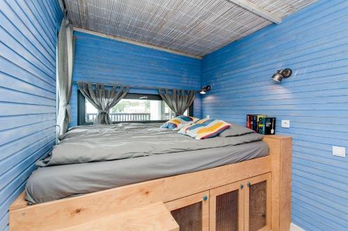 a bed in a blue room with a window at SOBIESZEPTY Odetchnij ciszą in Gdańsk