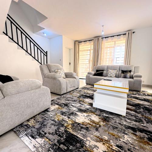 a living room with two couches and a table at Bertess in Kikuyu