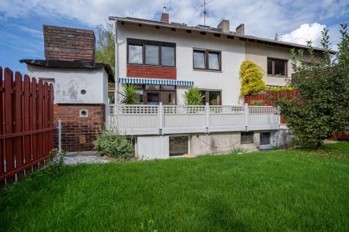 ein Haus mit einem weißen Zaun neben einem Hof in der Unterkunft Aparmtent im Münchner Westen, Parkplatz kostenfrei, ruhig in Gröbenzell