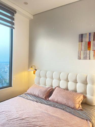 a bedroom with a large white bed with a window at LAD Apartment & Homestay Hải Phòng - Hoàng Huy Grand Tower in Hai Phong