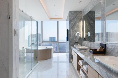 a bathroom with a tub and a sink and a shower at Wyndham Grand Istanbul Levent Hotel & Conference Center in Istanbul