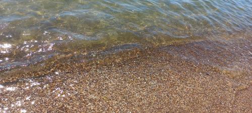 a close up of the sand and water on the beach at Гостевой дом Уют in Karolino-Buhaz