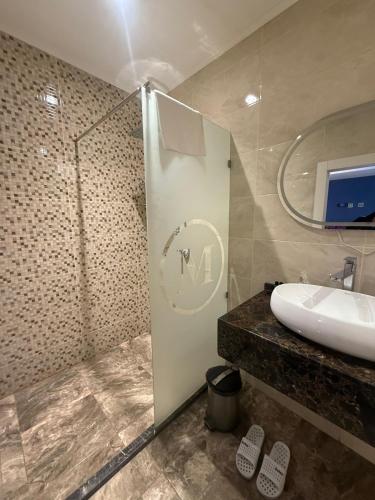 a bathroom with a sink and a glass shower at Black Mont İnn Hotel in Baku