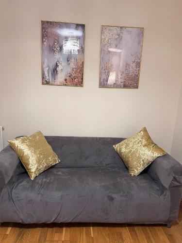 a couch with two pillows sitting under three pictures at Oxford four-Bedrooms detached house with driveway parking in Oxford