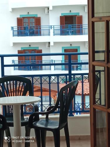 a table and chairs in front of a balcony at George Studios Stalis in Stalida
