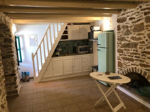 - une cuisine avec un réfrigérateur et une table dans la chambre dans l'établissement La DESIRADE, à Symi