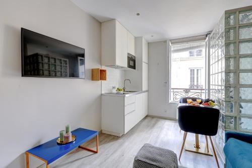 un salon avec une table bleue et une cuisine dans l'établissement BnBNook - Studio - Eiffel Tower & Les Invalides, à Paris