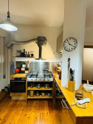 a kitchen with a stove and a clock on the wall at Relax al Mare in Viareggio