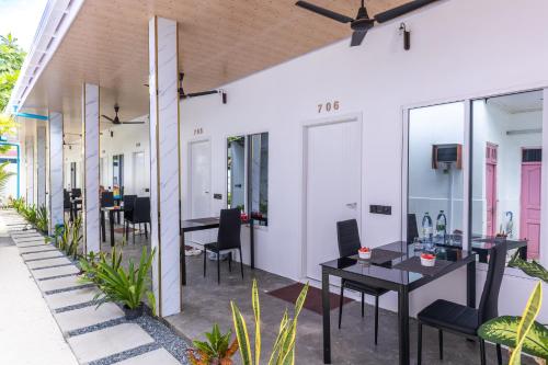 an outdoor patio with tables and chairs and windows at Rangali thoddoo Maldives in Thoddoo
