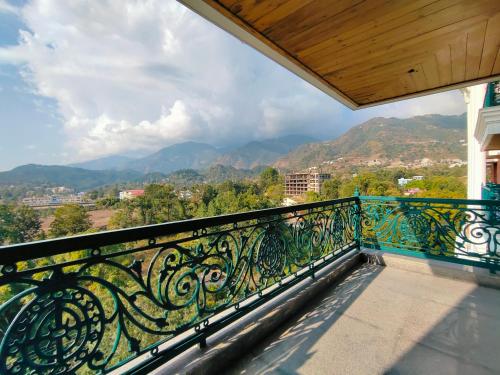 a balcony with a railing with a view of mountains at Eden Wellness and Hospitality in Dehradun