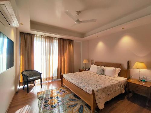 a bedroom with a bed and a chair and a window at Eden Wellness and Hospitality in Dehradun