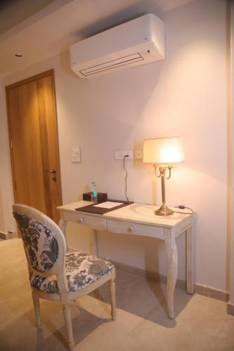 a desk with a lamp and a chair in a room at Eden Wellness and Hospitality in Dehradun