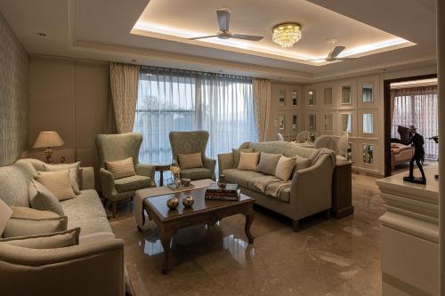 a living room with couches and chairs and a table at Eden Wellness and Hospitality in Dehradun