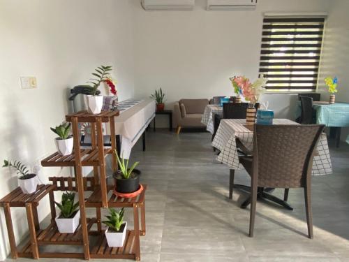 a living room with a table and chairs and plants at Manta Sky Inn in Dharavandhoo