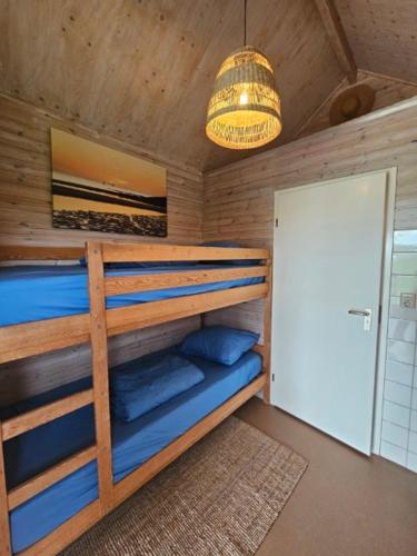 a bedroom with bunk beds and a chandelier at Surf Shack in Scharendijke