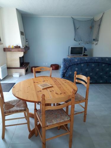 une table et des chaises en bois dans un salon dans l'établissement Charmante maison vendéenne avec jardin et océan à 200m, à Saint-Hilaire-de-Riez