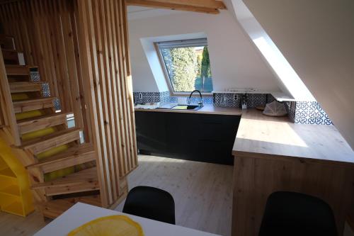 a kitchen with a counter with a window and chairs at Pyramida pod Lysou s vířivkou in Frýdlant nad Ostravicí