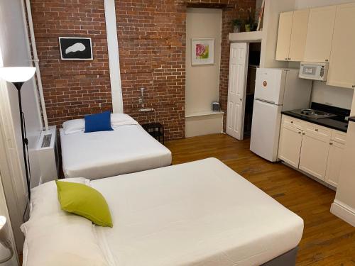 ein kleines Zimmer mit zwei Betten und einer Ziegelwand in der Unterkunft Nest Family Aparthotel - No Window in New York