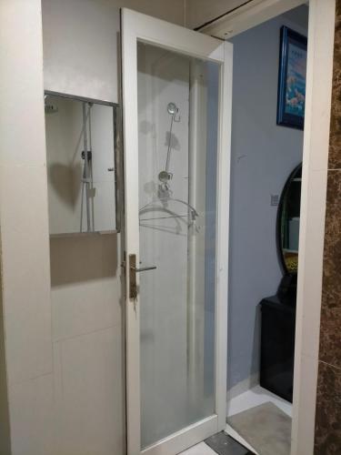 a glass shower door in a bathroom at Kouzui Homestay in Surabaya