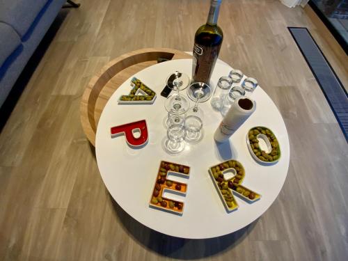 a white table with a bottle of wine and glasses at Artik chalet avec vue à 180 degrés et piscine in Les Angles