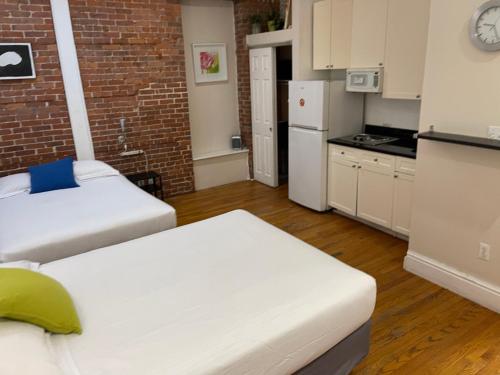 eine kleine Küche mit 2 Betten und einem weißen Kühlschrank in der Unterkunft Nest Family Aparthotel - No Window in New York