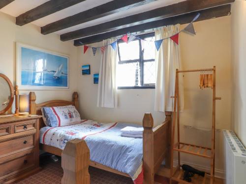 a bedroom with a bed and a window at The Studio Cottage in Cemaes Bay