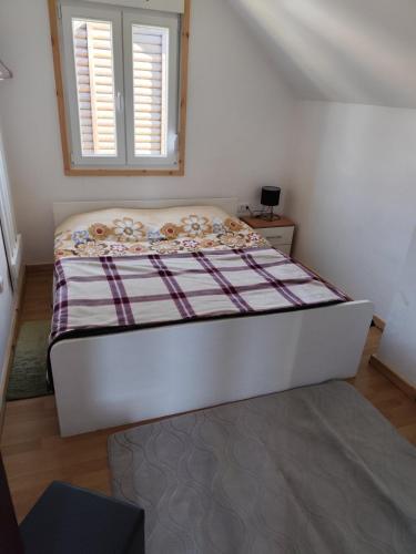 a bed in a room with a window at BAH house in Kolašin