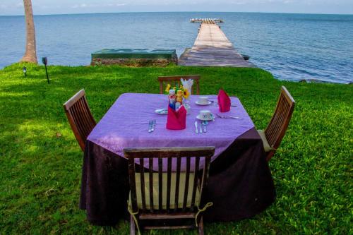 a table with a purple table cloth and a pier at Rusinga Island Lodge in Mbita