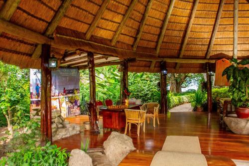 an outdoor dining area of a house with a wooden ceiling at Rusinga Island Lodge in Mbita