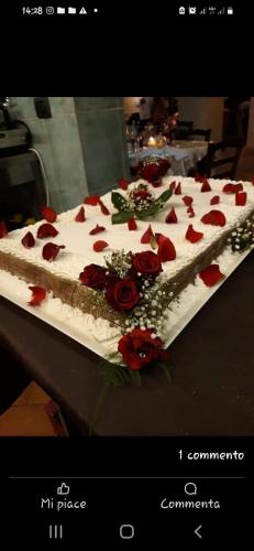 a large white cake with red roses on a table at Podere Cerciano in Radicondoli