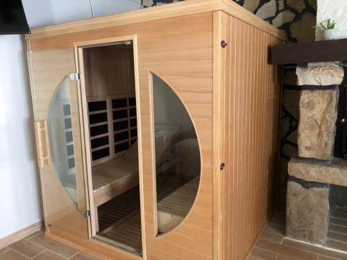 a wooden cabinet with a mirror in a room at Le Petit Paradis de Marcelise in Le Ponchel