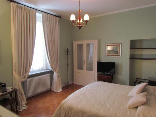 コモにあるAl Porticciolo di Sant'Agostinoのベッドルーム1室(ベッド1台、シャンデリア付)